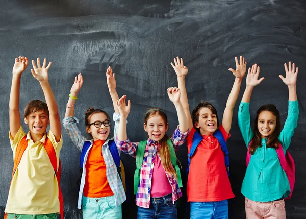 Schüler heben Hände an der Tafel — Stockfoto