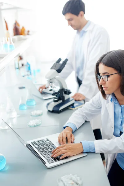 Pretty scientist typing on laptop — Stock Photo, Image
