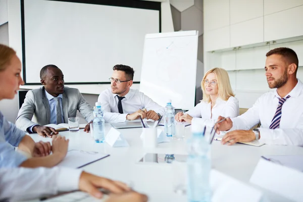 Groep van managers bespreken statistieken tijdens bijeenkomst — Stockfoto