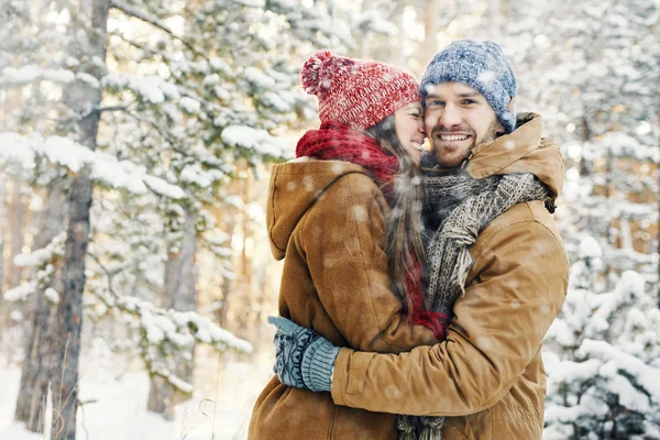 Chico feliz abrazando a su novia en las nevadas — Foto de Stock
