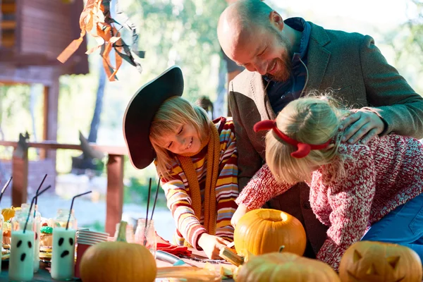 Mann und seine Töchter betrachten Halloween-Symbole — Stockfoto