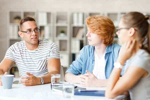 Group of young people interacting at briefing — Stock Photo, Image