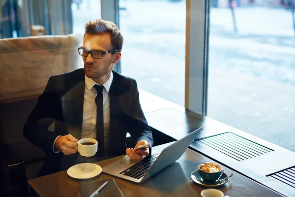 Uomo d'affari che controlla e-mail con tazza di caffè — Foto Stock