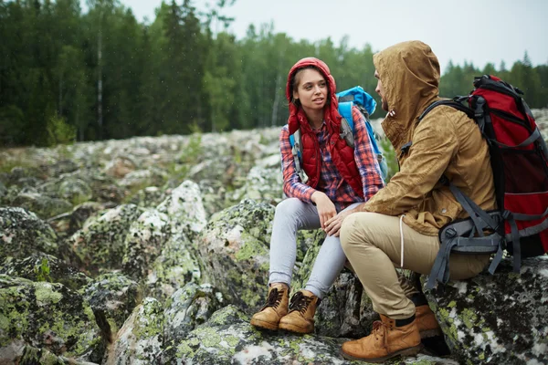 Amorosos excursionistas sentados en grandes piedras —  Fotos de Stock
