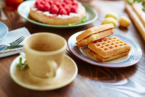 Sweet snack on plate and cup of tea — Stock Photo, Image