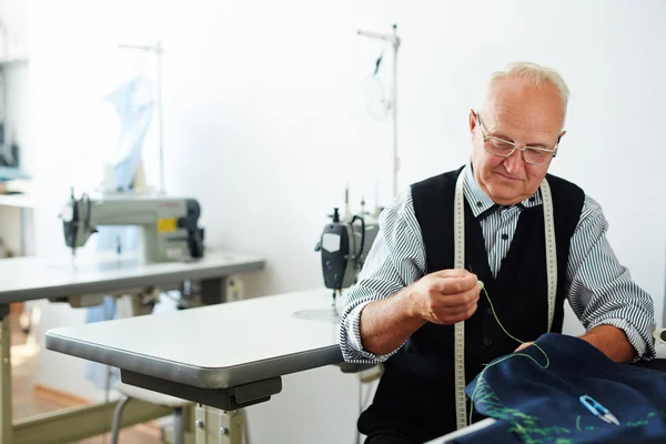 Muž šití oblečení v krejčovství obchod — Stock fotografie