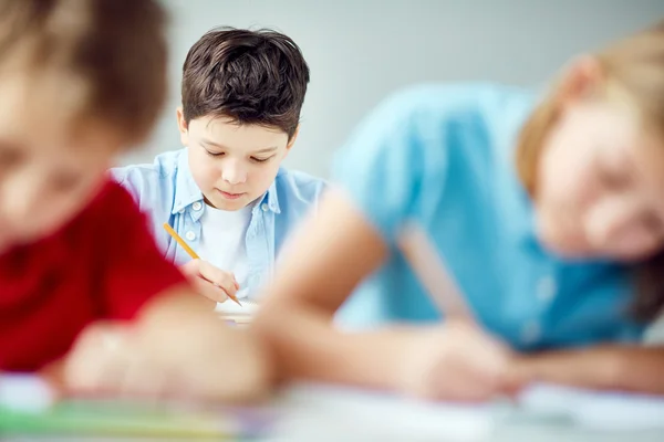 Pupil carrying out written task at lesson Royalty Free Stock Images