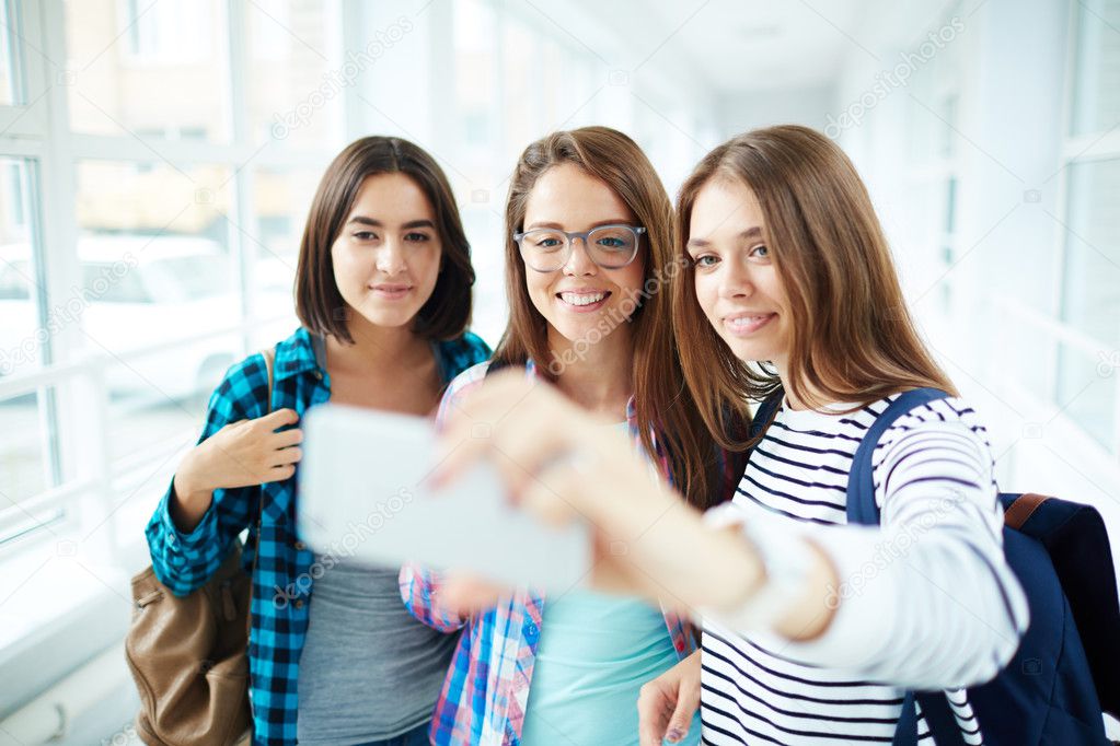 Student girls taking selfie at school 