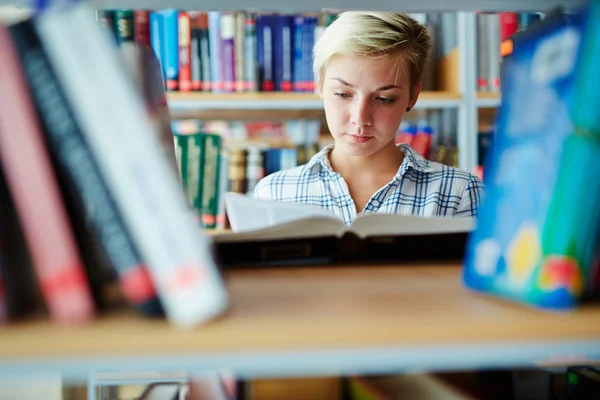 Junge Studentin liest in Bibliothek — Stockfoto