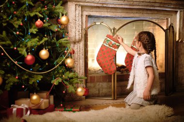 Küçük kız giftbox Noel çorap koyarak