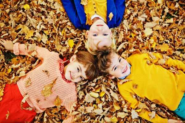 三个孩子躺在落叶 — 图库照片