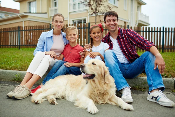 Семья с домашним животным рядом со своим новым домом — стоковое фото