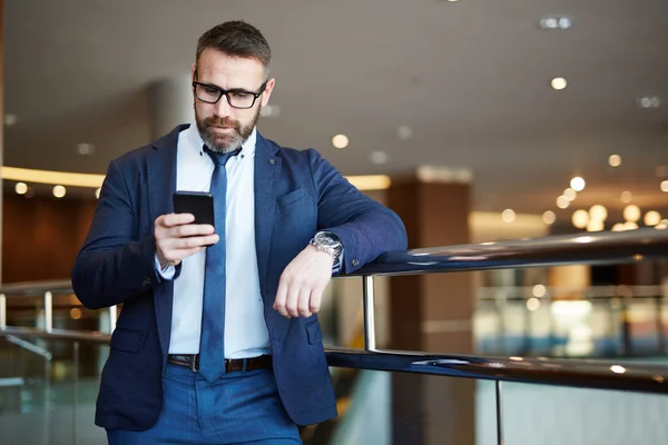 Busiessman navegando por la red en su smartphone —  Fotos de Stock