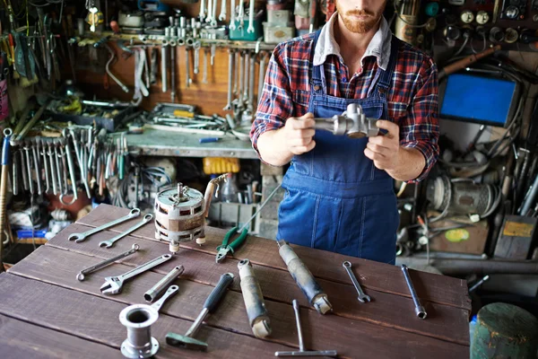 Jonge mechanic stalen deel houden — Stockfoto