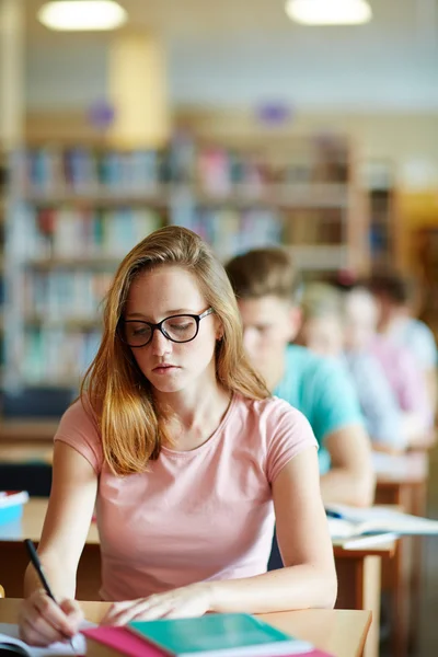 Pensive student making notes in copybook — Stock Photo, Image