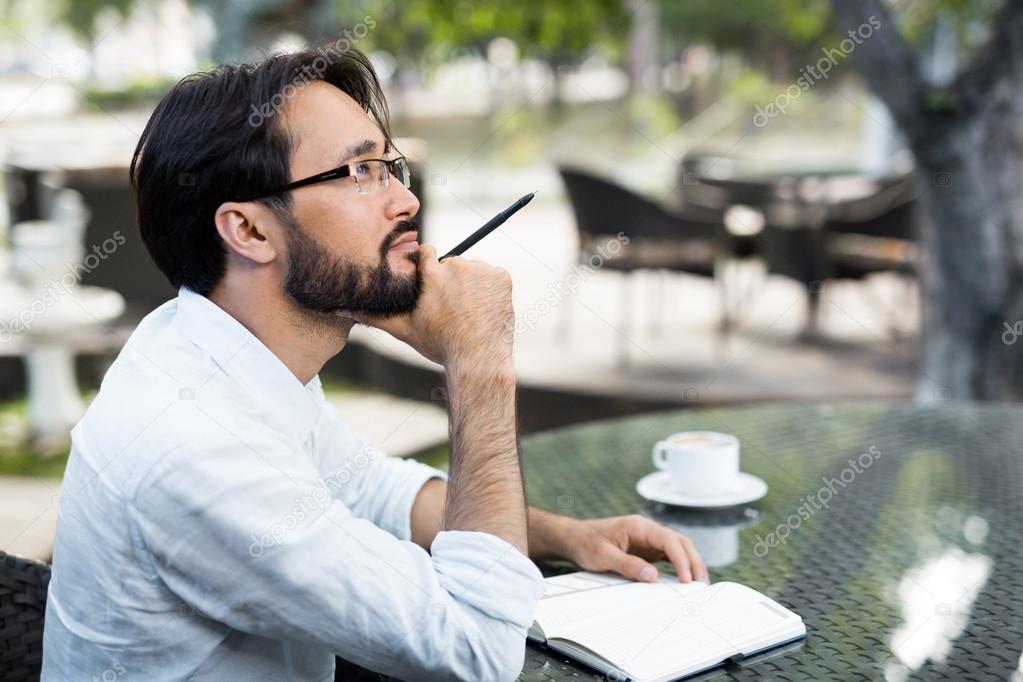 Inspired Asian man sitting in cafe 