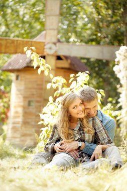 Çimenlerin üzerinde oturan iki sarılma insanlar 