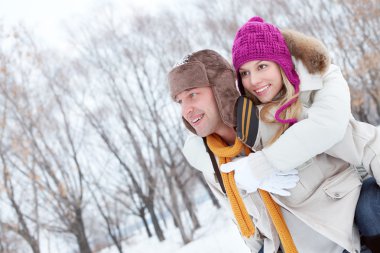 Bir adam kız arkadaşını sırtında taşıyor.
