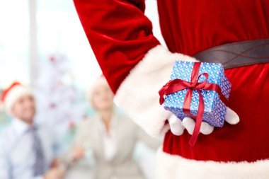 Noel Baba hediye kutusu arkasından tutarak