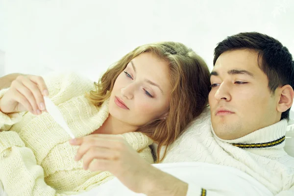 Unhappy spouses looking at digital thermometer — Stock Photo, Image