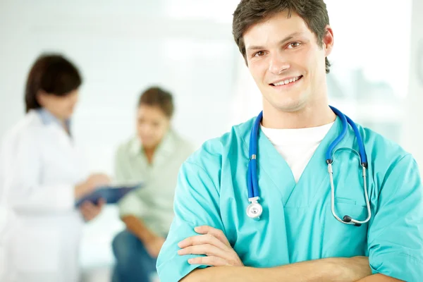 Male doctor smiling with arms crossed — Stock Photo, Image
