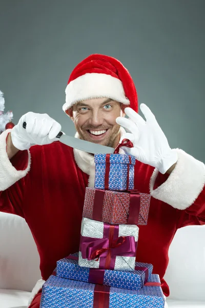 Böser Weihnachtsmann packt Weihnachtsgeschenke aus — Stockfoto