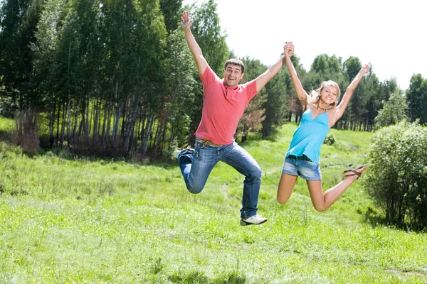 Glückliche Menschen springen in den Wald — Stockfoto