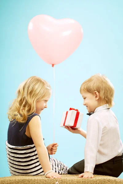 Kleine jongen geven een geschenk aan meisje — Stockfoto