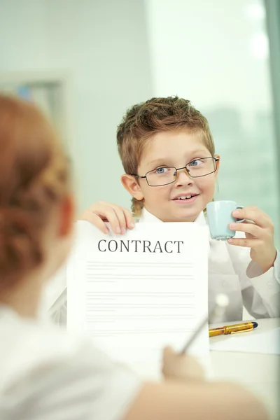 Niño pequeño mostrando contrato en la oficina —  Fotos de Stock