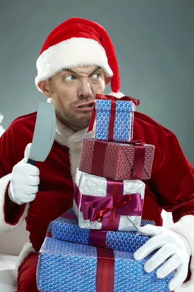 Санта собирается разрезать стопку подарочных коробок — стоковое фото