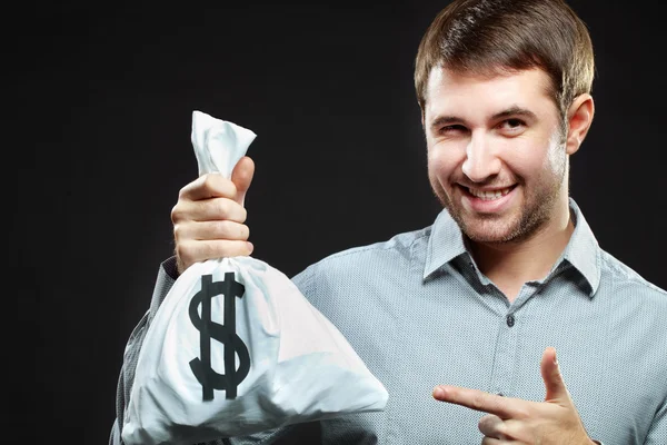 Man holding money bag and winking — Stock Photo, Image