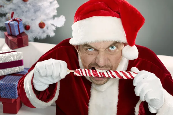 Crazy Santa gnawing lollipop — Stock Photo, Image