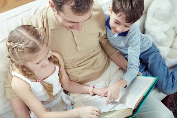 Vader lezing sprookje met zijn kinderen — Stockfoto