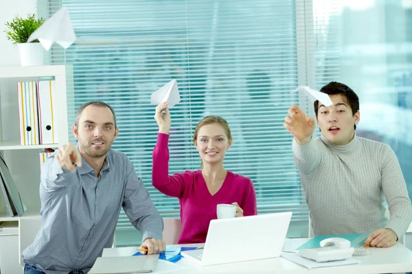 Pessoas jogando aviões de papel no escritório — Fotografia de Stock