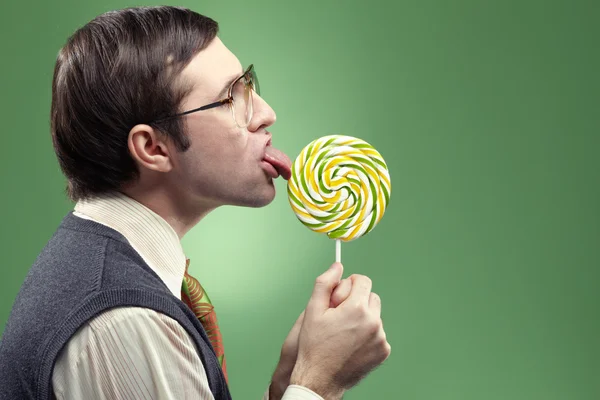 Childish adult nerd sucking a lollipop — Stockfoto