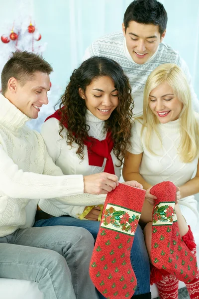 People preparing Christmas stockings for holiday — ストック写真