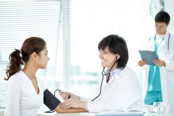 Sorridente medico esaminando il suo paziente — Foto Stock