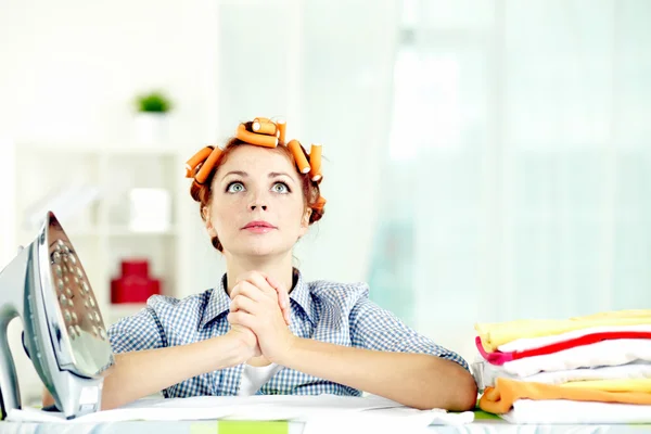 Housewife praying by ironing board — Stock Photo, Image