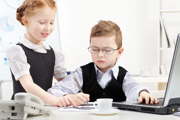 Liten pojke och flicka som arbetar på kontor — Stockfoto