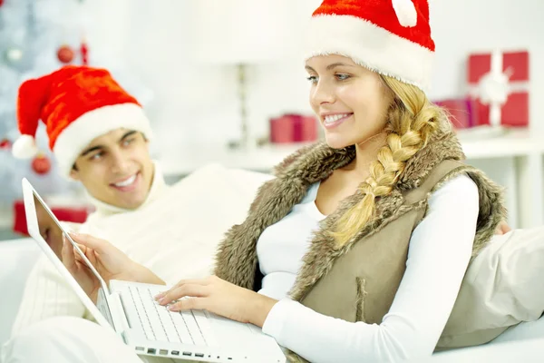 Girl in Christmas hat surfing the net — Stock Photo, Image