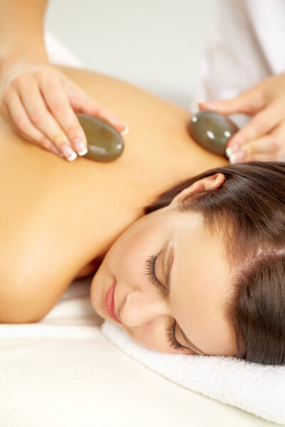Woman being massaged with stones