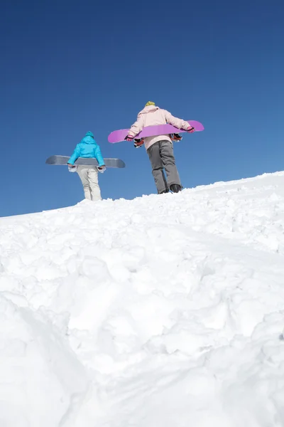 Dois snowboarders escalando na colina — Fotografia de Stock