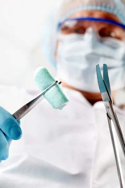 Clamp and forceps in surgeon's hands — Stock Photo, Image