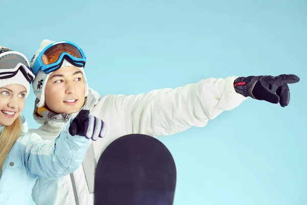 Snowboarder sorridenti che puntano a qualcosa — Foto Stock