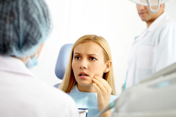 Mujer hablando con el doctor en el consultorio del dentista —  Fotos de Stock