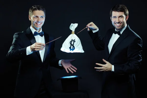 Magicians taking sack with money out — Stock Photo, Image