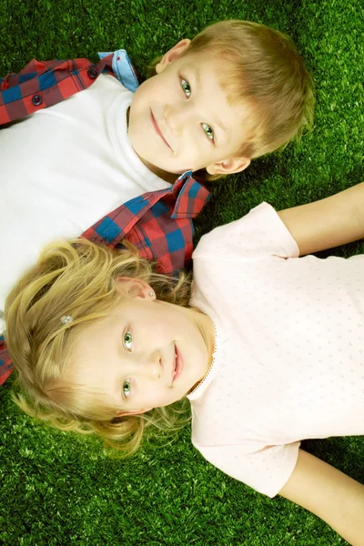 Cute children lying on grass — Stock Photo, Image