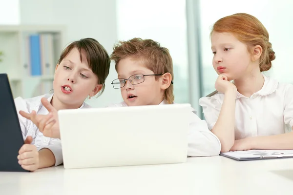 Niños de negocios discutiendo algo en la computadora —  Fotos de Stock