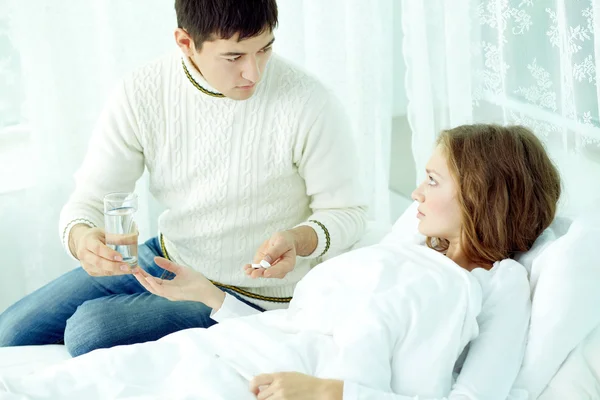 Homem dando pílulas para sua esposa doente — Fotografia de Stock