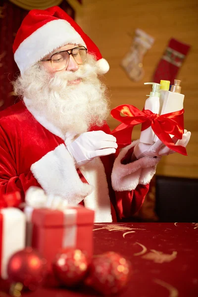 Santa preparing Christmas presents for women — Stock Photo, Image